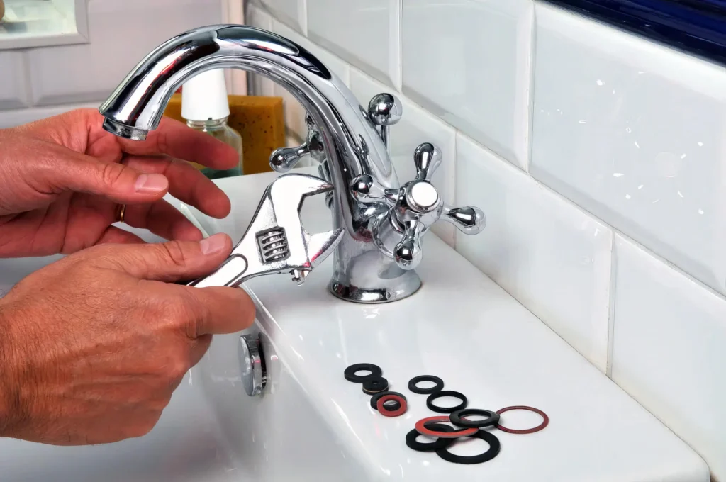 Plumber performing maintenance on a bathroom faucet in Warrington