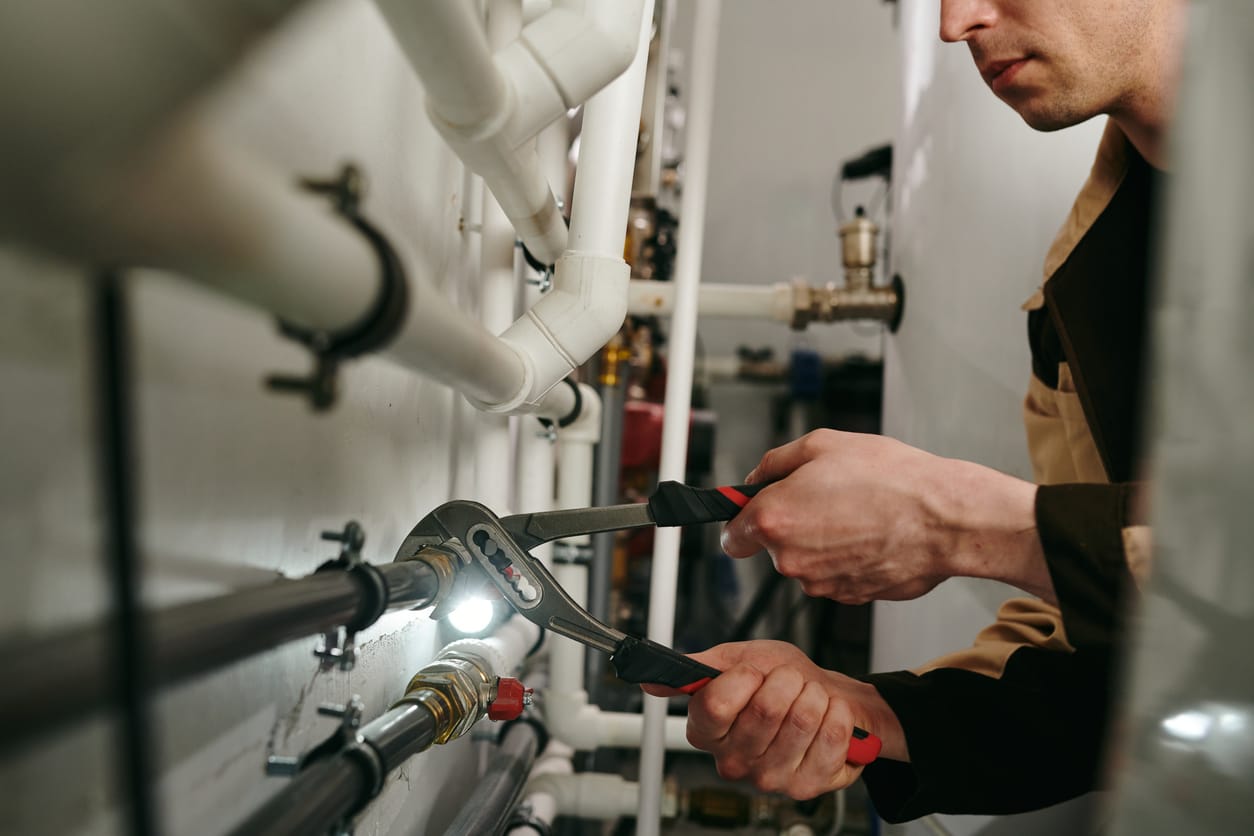Plumbers maintaining commercial plumbing pipes in Warrington