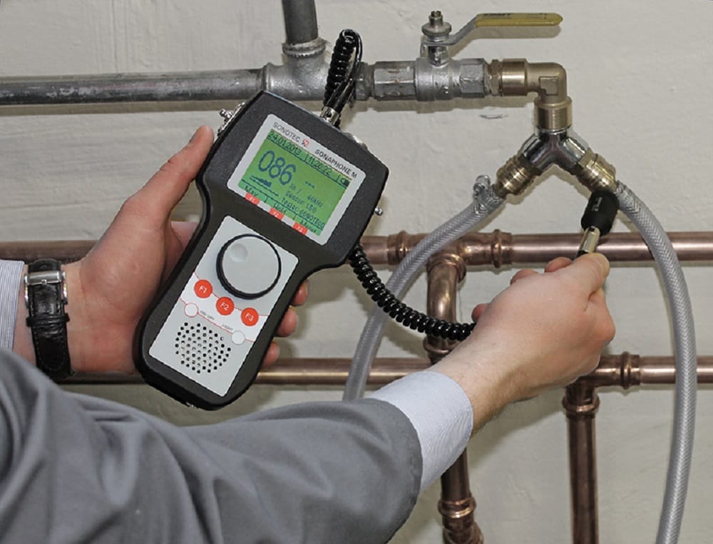 Plumber testing pipes with electronic leak detection equipment in Warrington