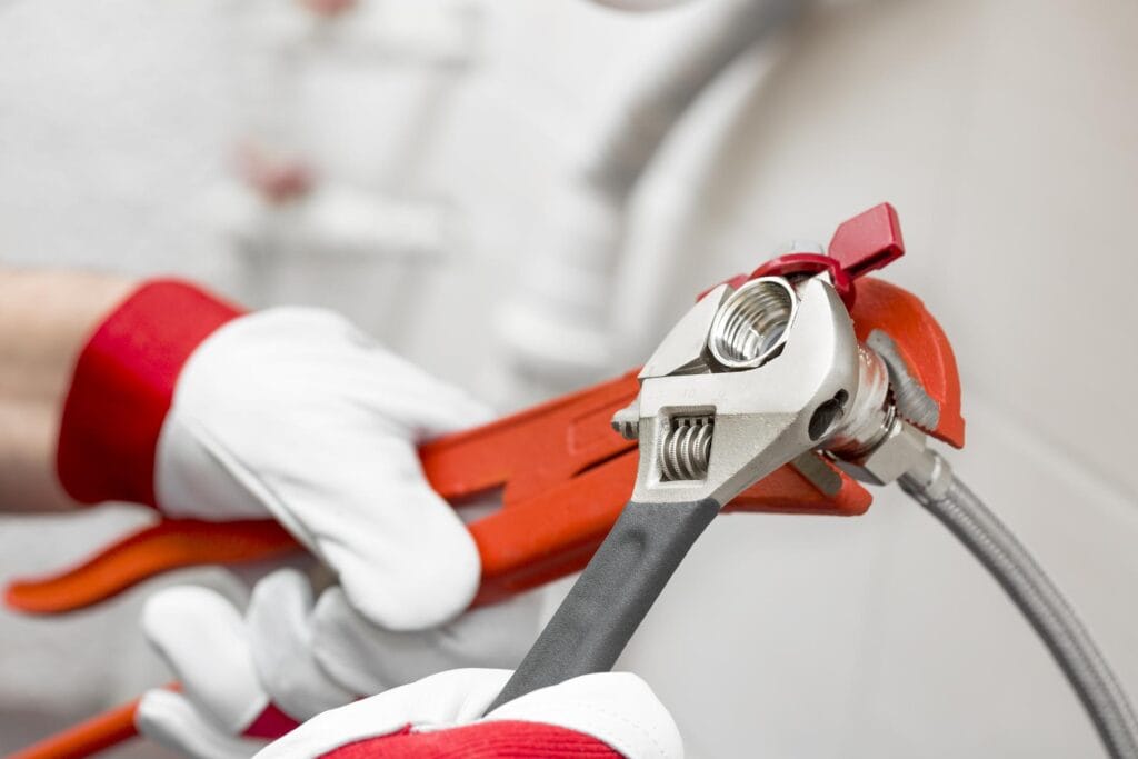 Plumber holding pipe wrenches for an emergency repair in Warrington