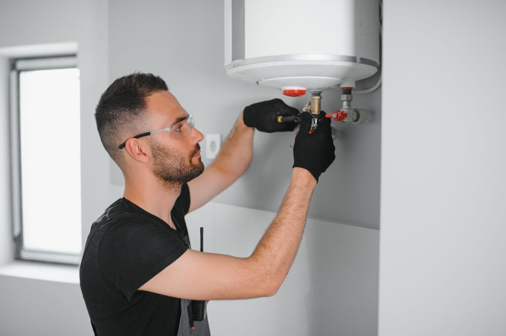 Technician performing water heater maintenance in Warrington