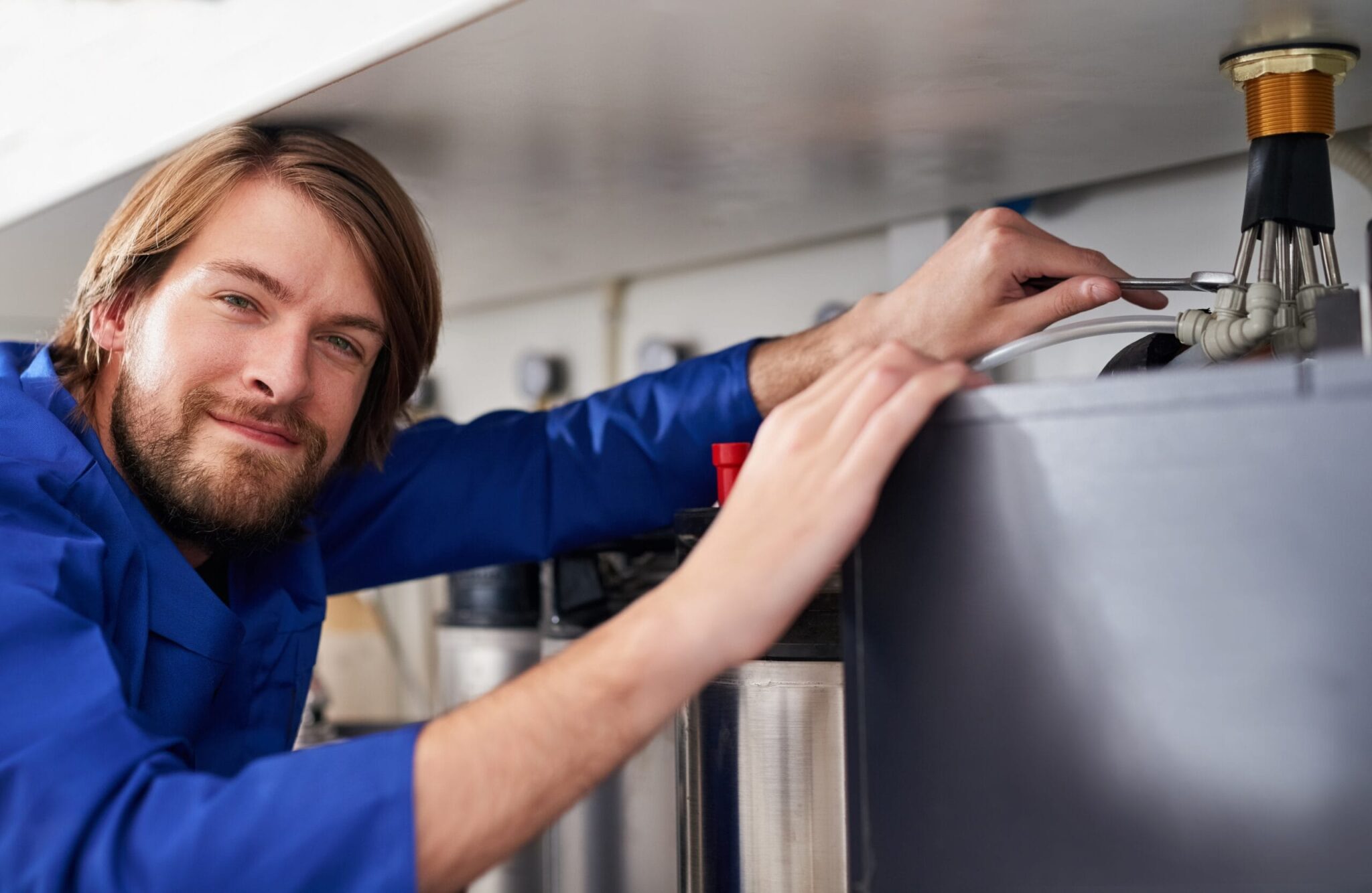 Technician servicing a residential water heater tank in Warrington