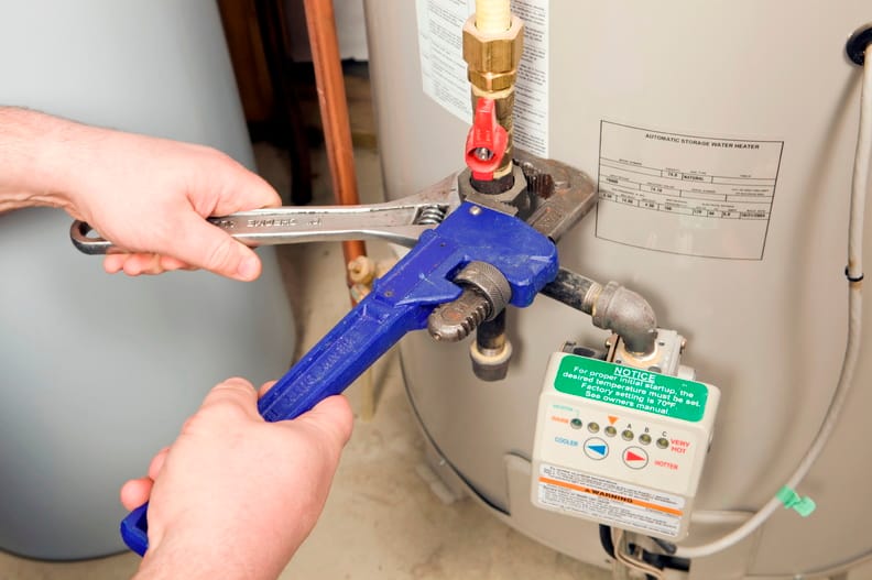 Plumber repairing a water heater valve in Warrington